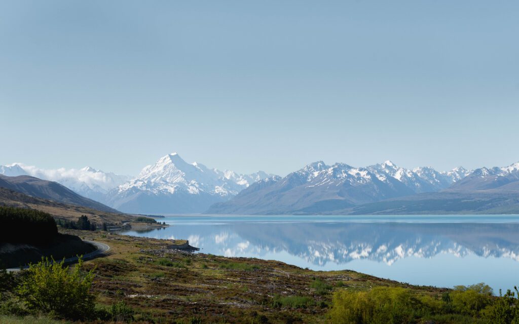 Aoraki Mount Cook reflected in the turquoise glacial waters of Lake Pukaki on a clear sunny day, New Zealand