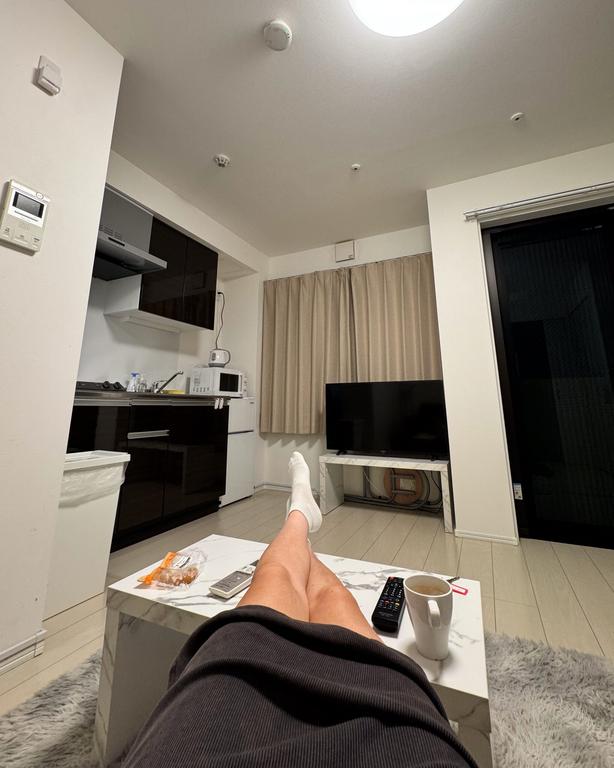 Relaxing with feet up on a coffee table inside a compact Tokyo apartment living room