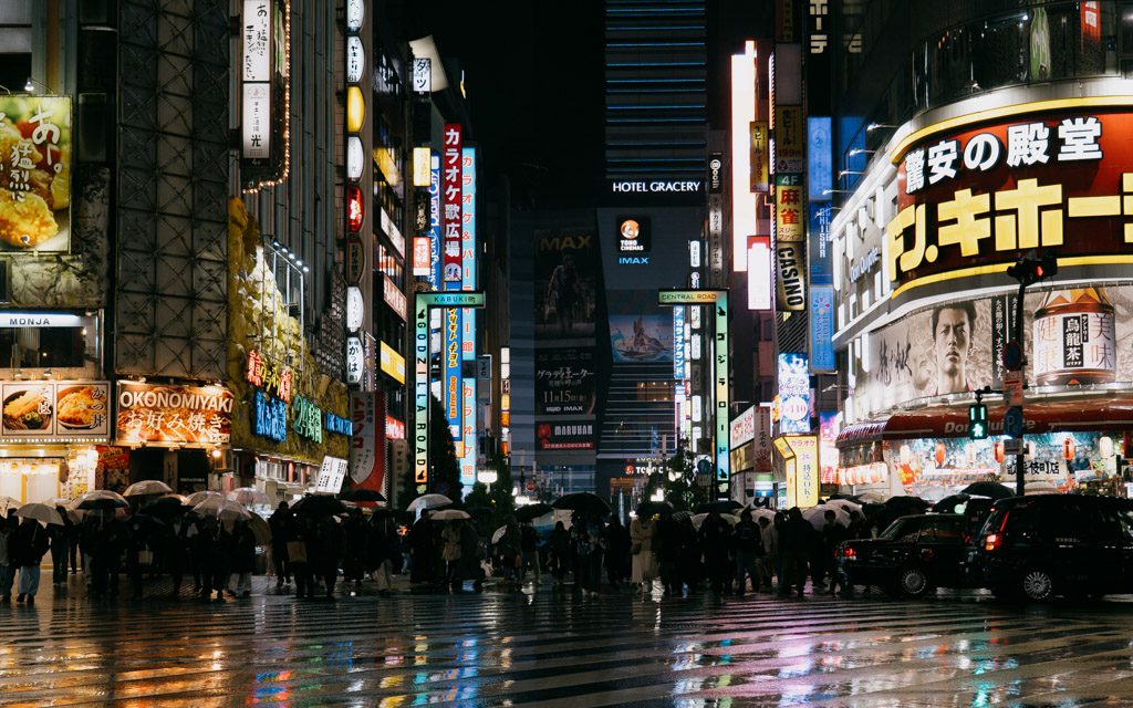 Neon signs reflecting on wet streets in Kabukicho, Shinjuku at night