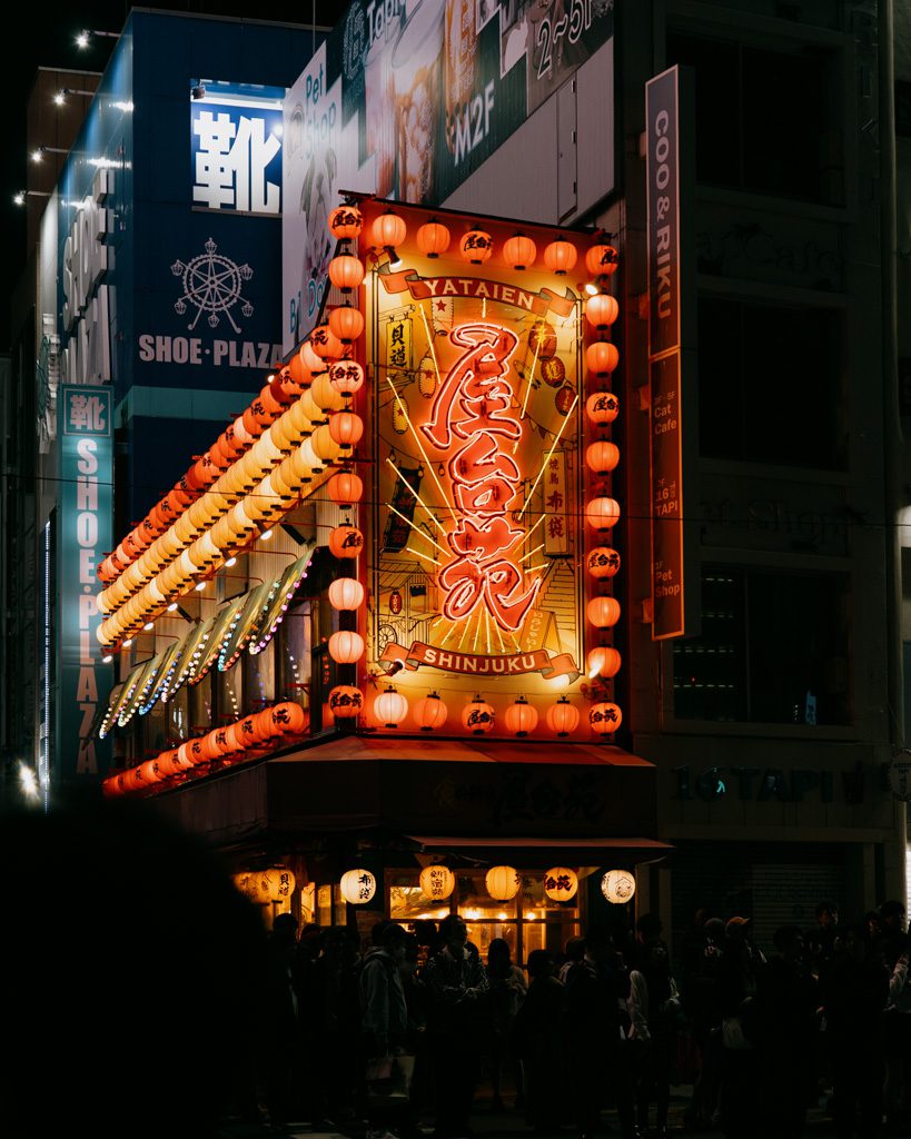 Rows of glowing orange lanterns lining the Yataien izakaya storefront in Shinjuku at night