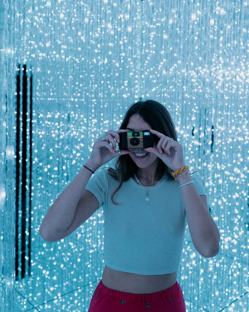 Visitor inside a mirrored room of sparkling light strands at TeamLab Planets, Tokyo