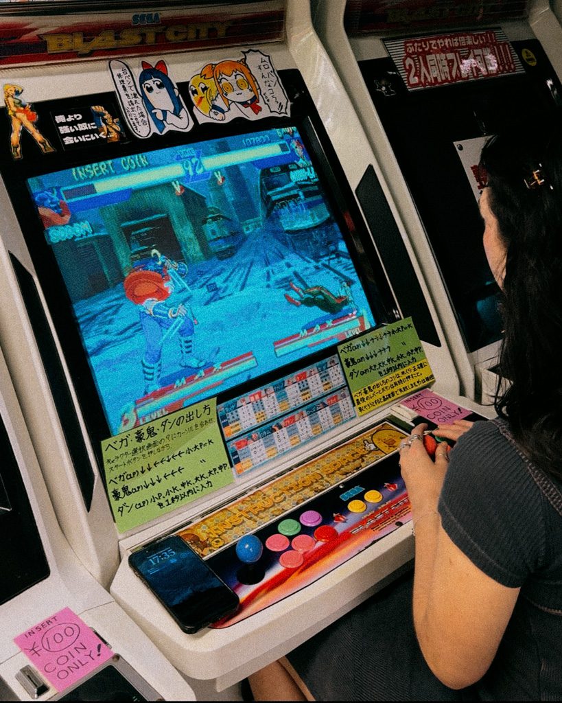 Playing a retro fighting game on an arcade cabinet in an Akihabara arcade