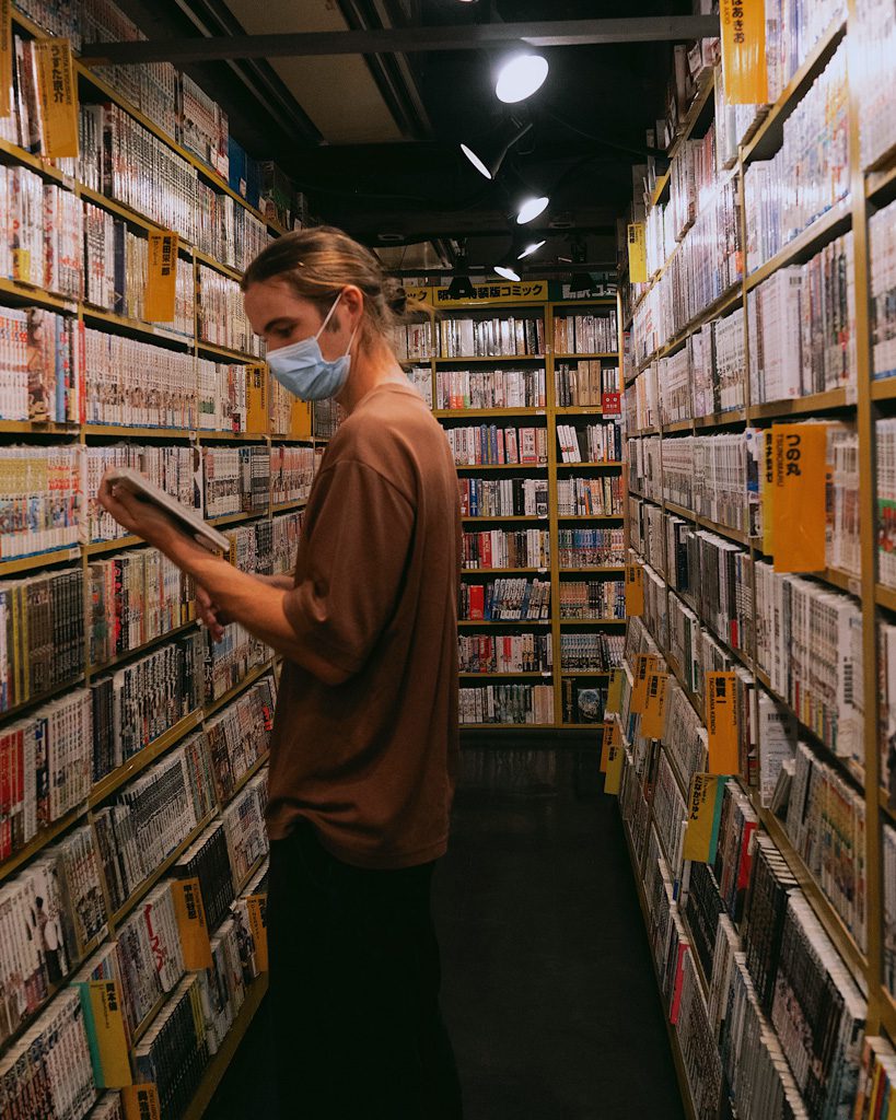Visitors browsing manga and anime merchandise in an Akihabara shop
