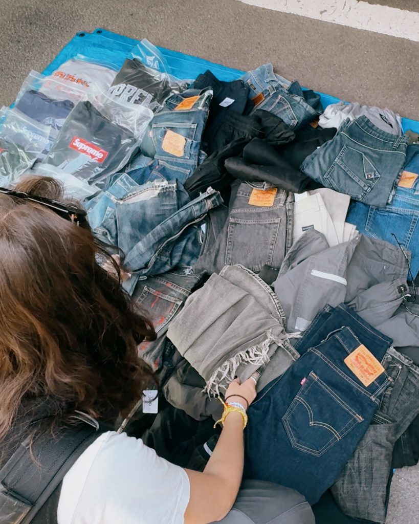 Sifting through a pile of vintage denim and streetwear at the Oi Racecourse flea market