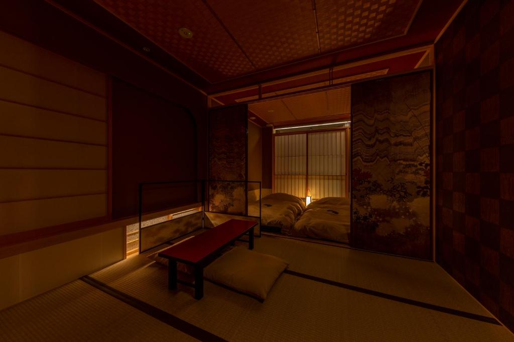 Traditional tatami bedroom at Cyashitsu Ryokan Asakusa with low futon beds and patterned sliding doors