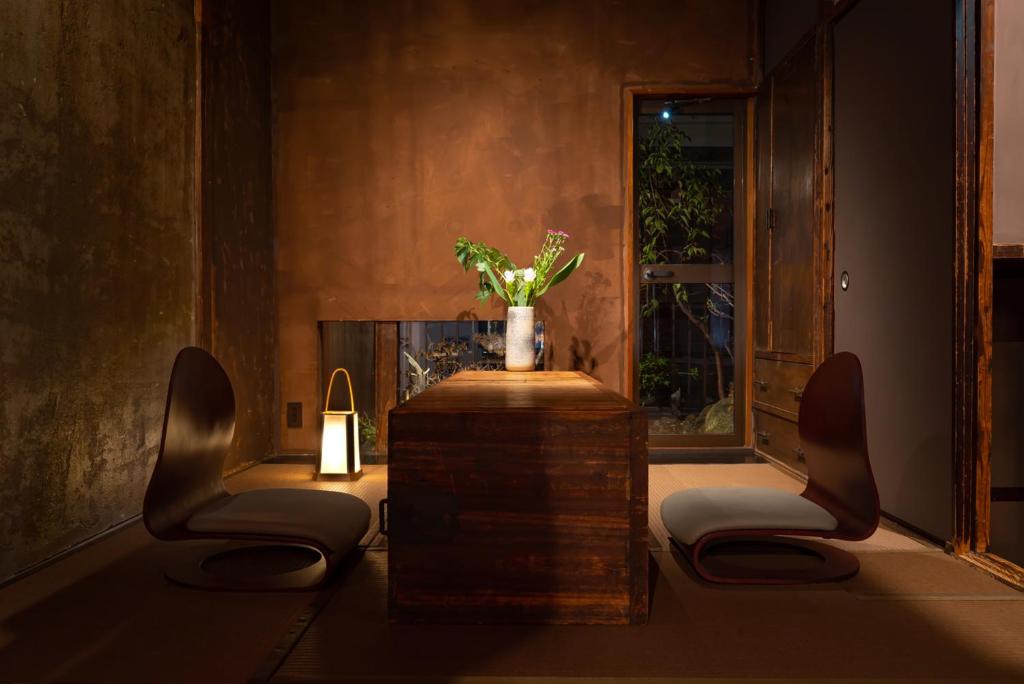 Minimalist tea-room-inspired seating area at Cyashitsu Ryokan Asakusa with floor chairs and a wooden table