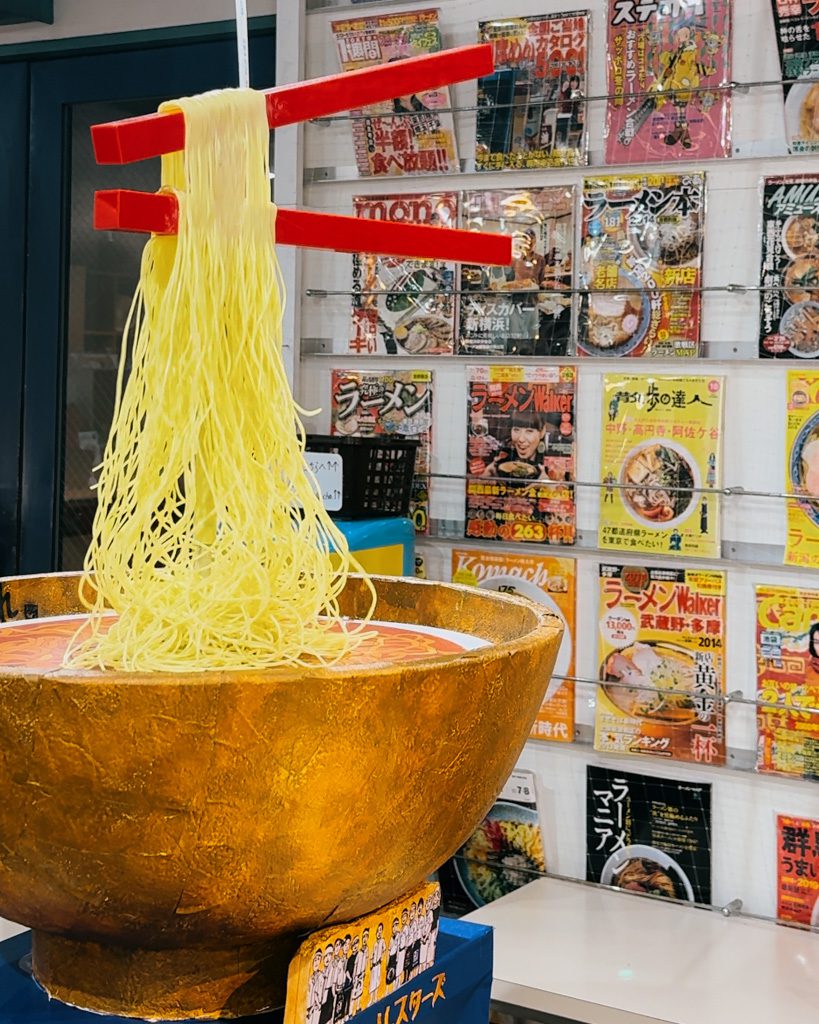 Oversized ramen bowl sculpture with chopsticks lifting noodles, a photo spot at the Shin-Yokohama Ramen Museum