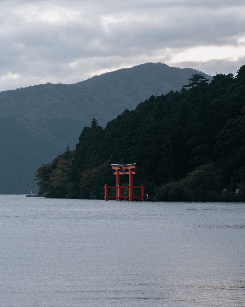 Close view of the red torii gate standing in the water of Lake Ashi, Hakone