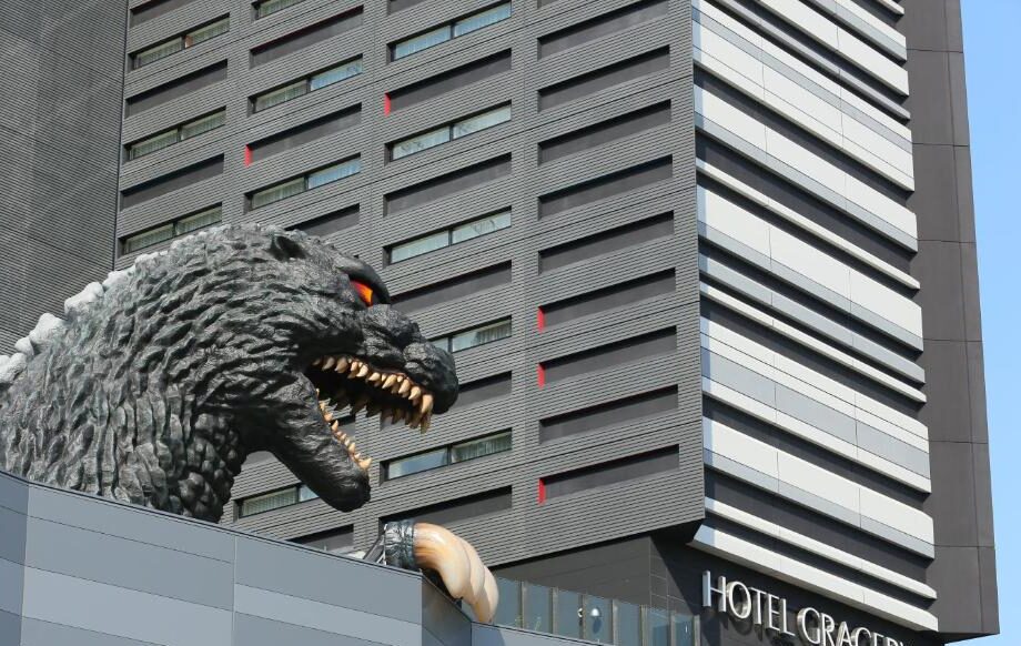 Life-size Godzilla head statue looming over the Hotel Gracery Shinjuku building