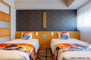 Twin hotel room with patterned cushions and mountain-print bedding