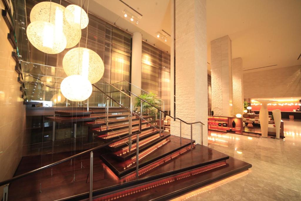 Modern hotel lobby with a wooden staircase and round hanging lantern lights