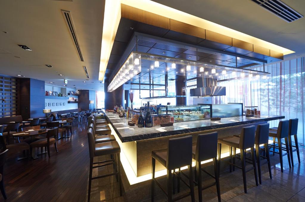Bar-style restaurant seating with stools overlooking an open counter and city view