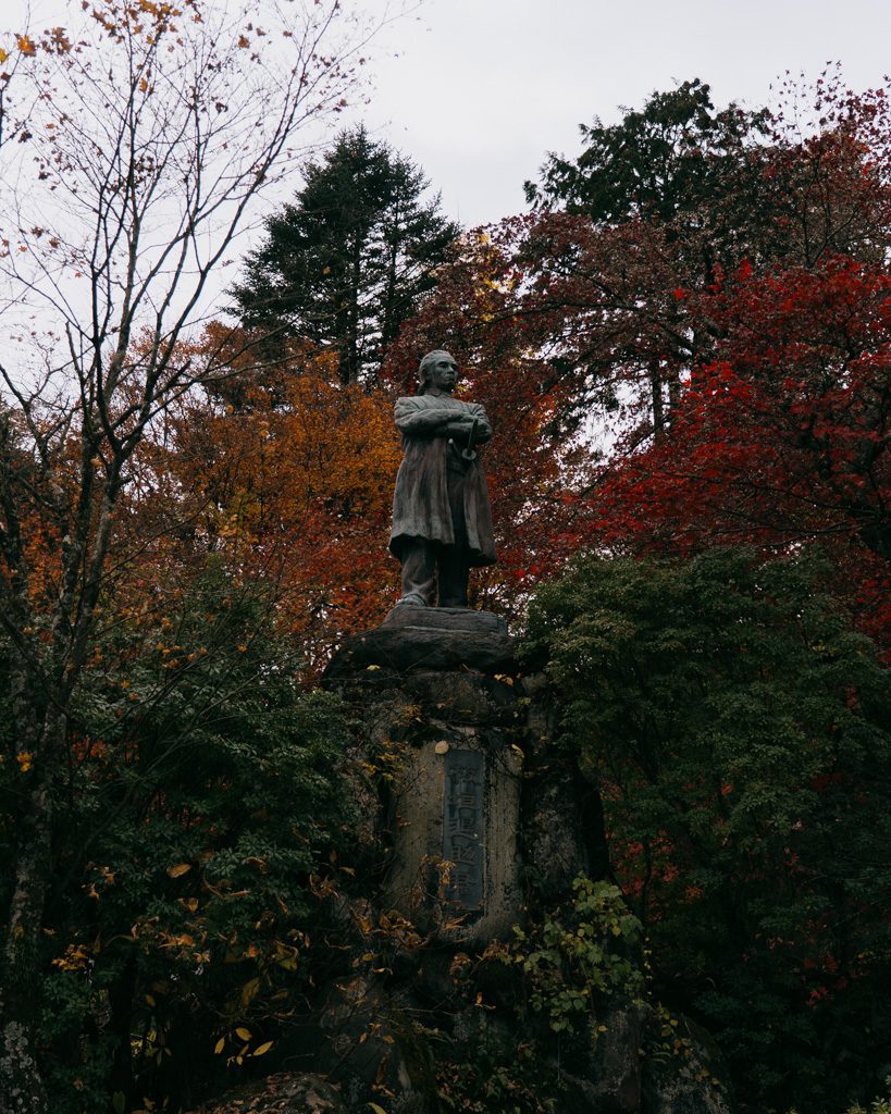 Itagaki Taisuke statue surrounded by red and orange autumn trees in Nikko