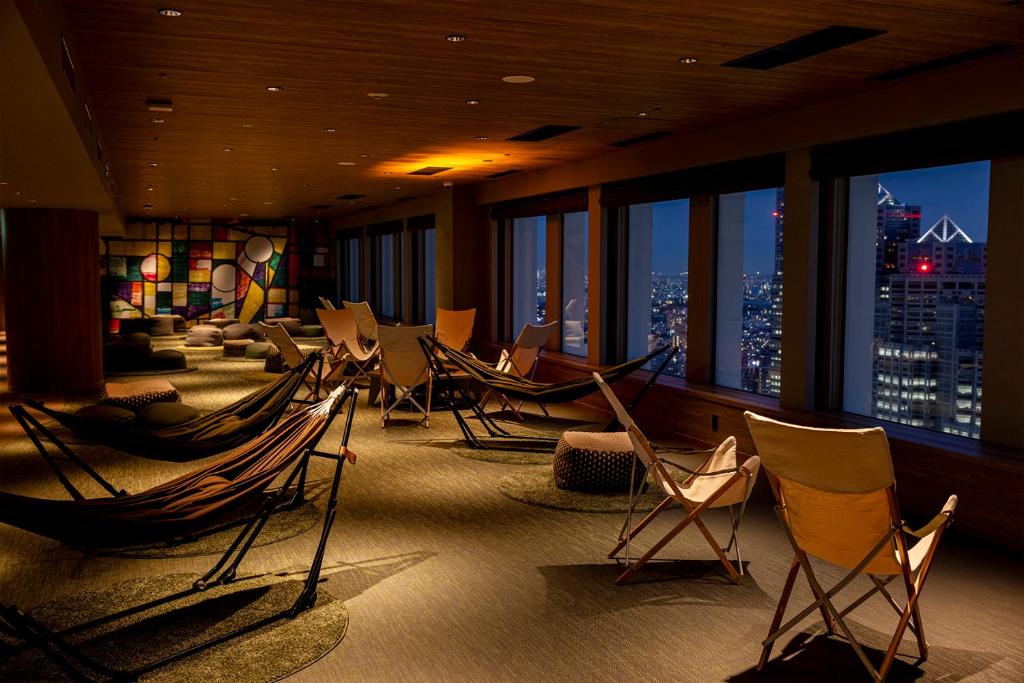Hotel lounge with hammocks and floor-to-ceiling windows overlooking Tokyo at night