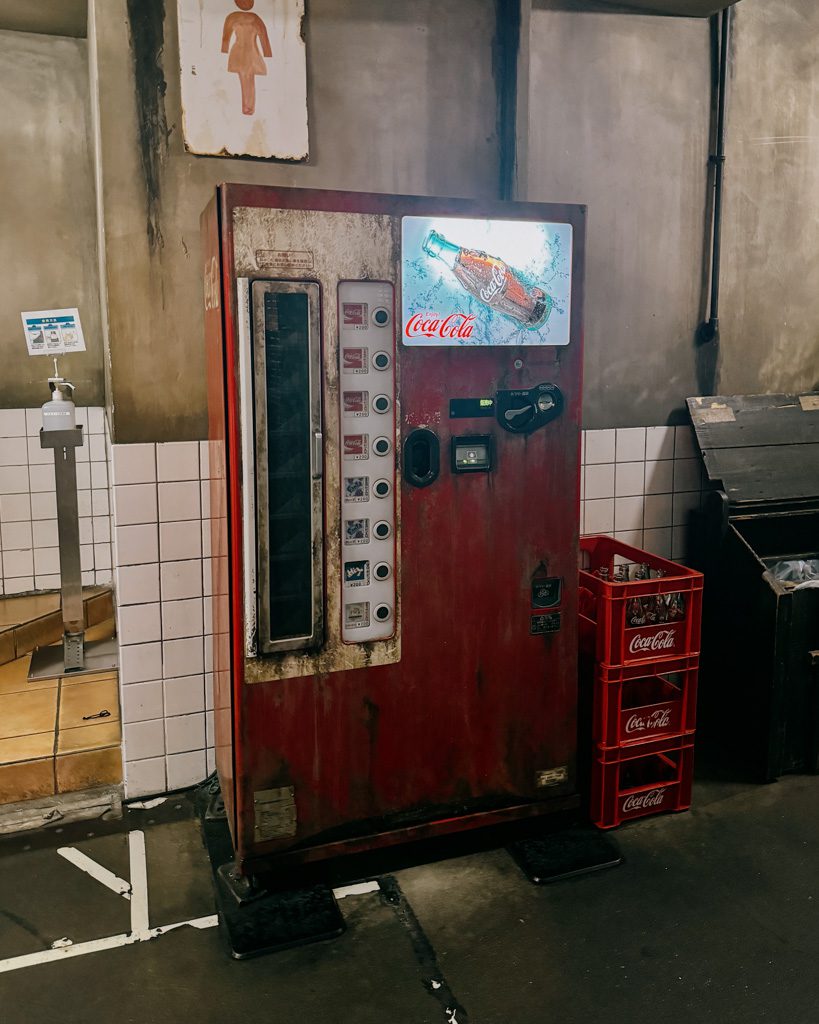 Weathered vintage Coca-Cola vending machine inside the Shin-Yokohama Ramen Museum