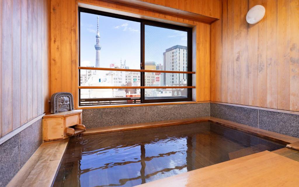 Hinoki wood bath at Ryokan Asakusa Shigetsu with a window view of Tokyo Skytree