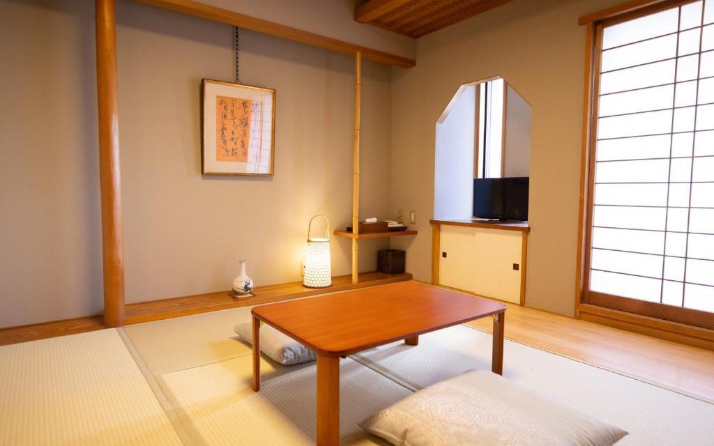 Traditional tatami room at Ryokan Asakusa Shigetsu with a low table, floor cushions, and shoji screens