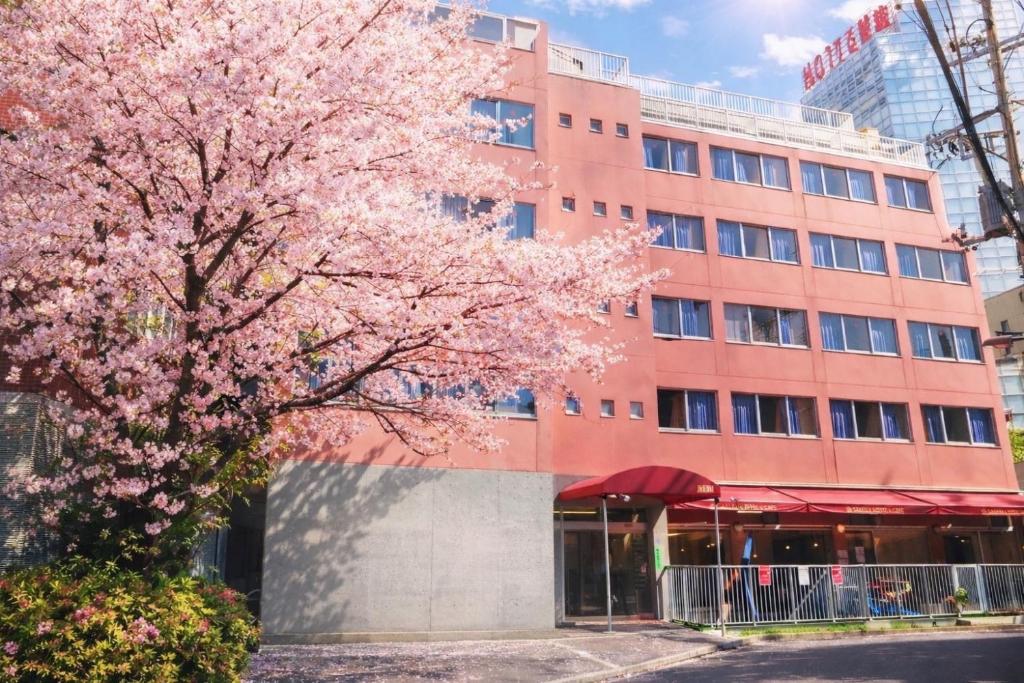 Exterior of Sakura Hostel Asakusa with a cherry blossom tree in full bloom