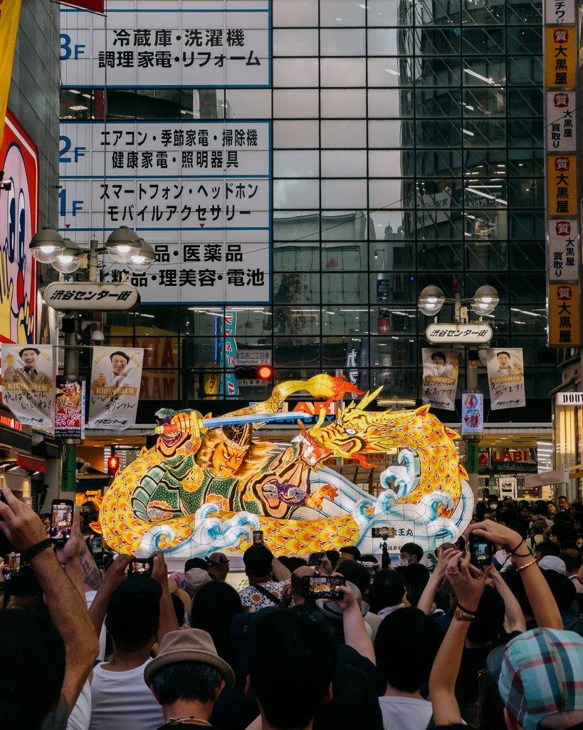 Crowds photographing an illuminated dragon Nebuta float during the Shibuya Nebuta Festival in Tokyo