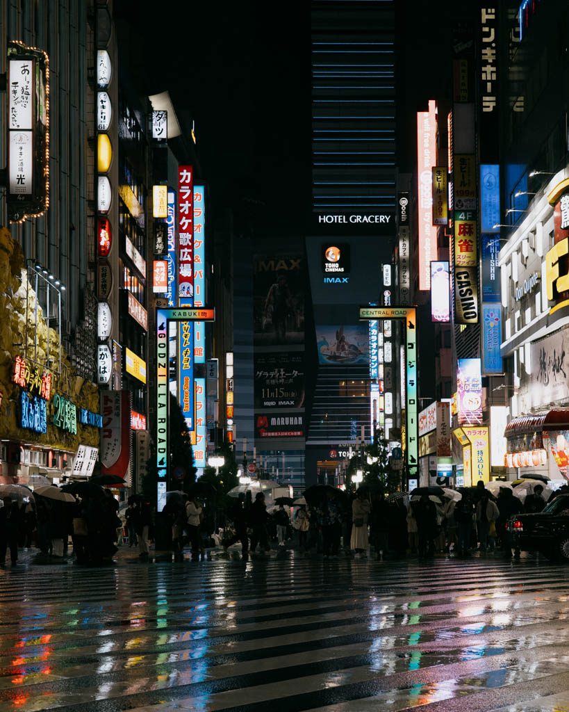 Rain-soaked Kabukicho street in Shinjuku lit up with neon signs at night