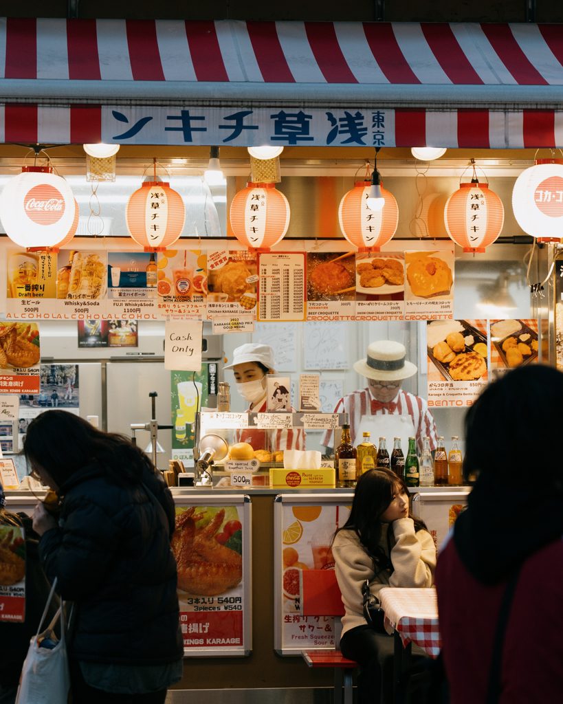 Street food vendor in Asakusa selling karaage and croquettes under red lanterns