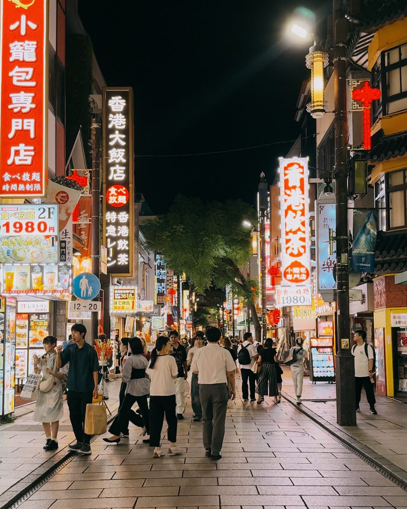 Yokohama Chinatown street at night, lit up with neon signs and lanterns