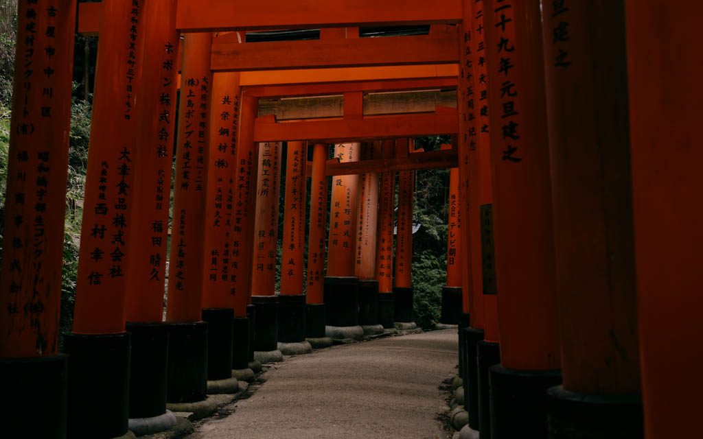 Empty stone path winding through torii gates at Fushimi Inari Shrine