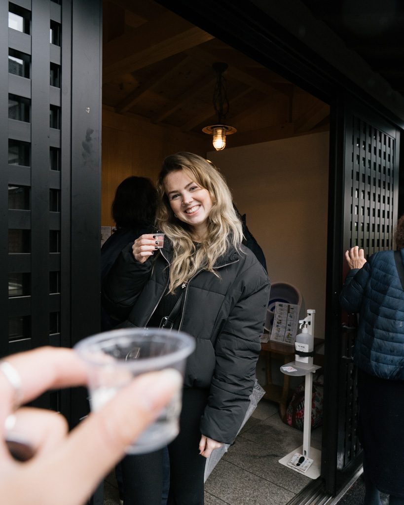 Sake tasting at Ide Sake Brewery, with tasting cups and the brewery's tatami entrance