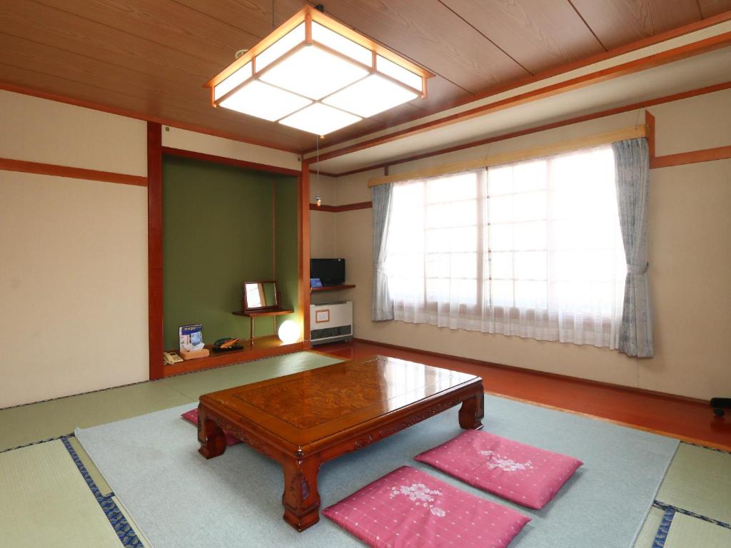 Traditional tatami mat room with low table and floor cushions at Ikemoto in Nozawa Onsen