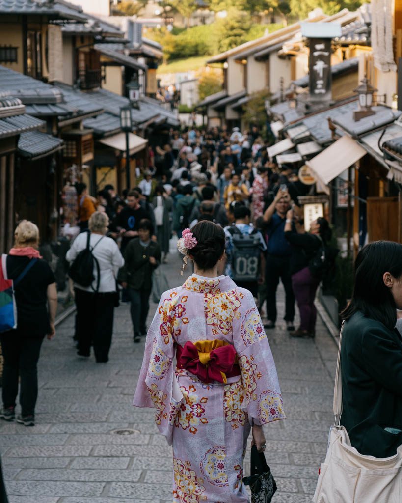 Woman in kimono walking through a crowded street in Kyoto's Gion district