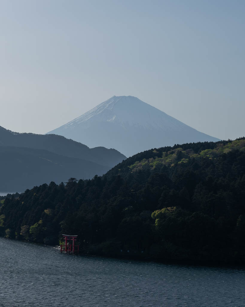 View of Mount Fuji and the Hakone Shrine torii gate from a quiet viewpoint above Lake Ashi