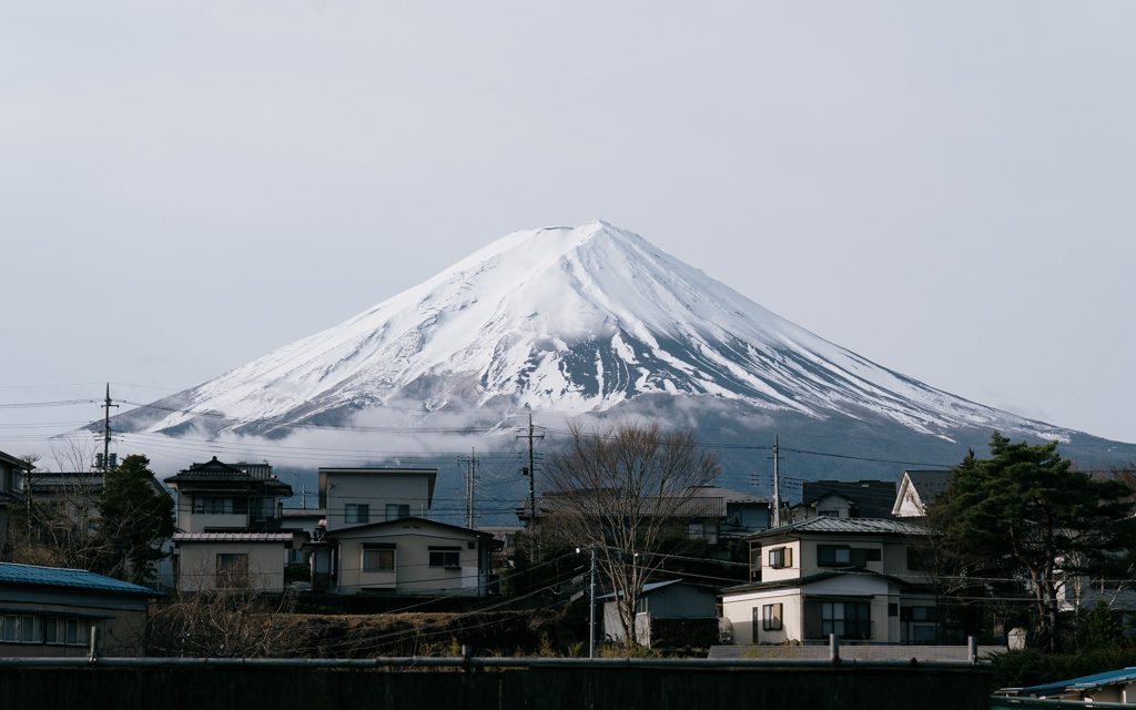 Snow-capped Mt Fuji rising above a residential neighbourhood in winter
