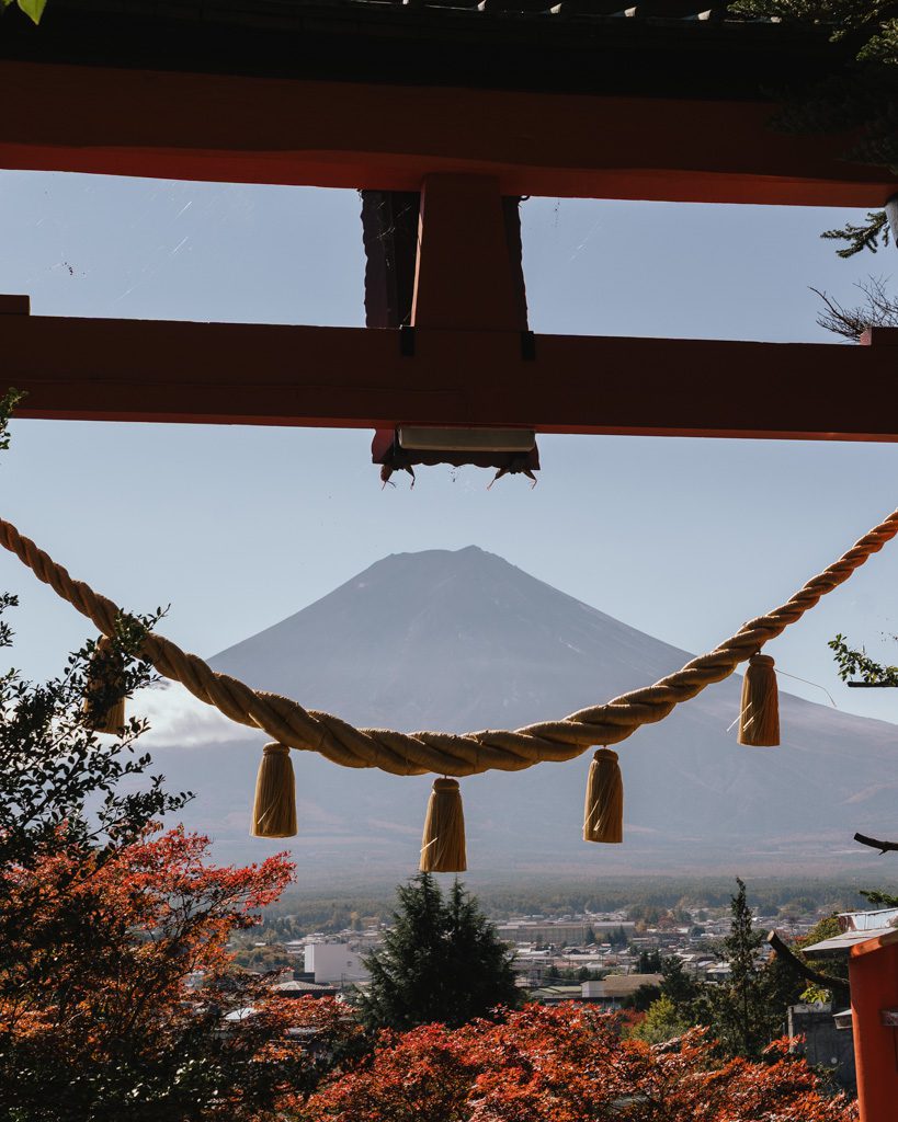Mt Fuji viewed through a torii gate with a shimenawa rope at Arakurayama Sengen Shrine