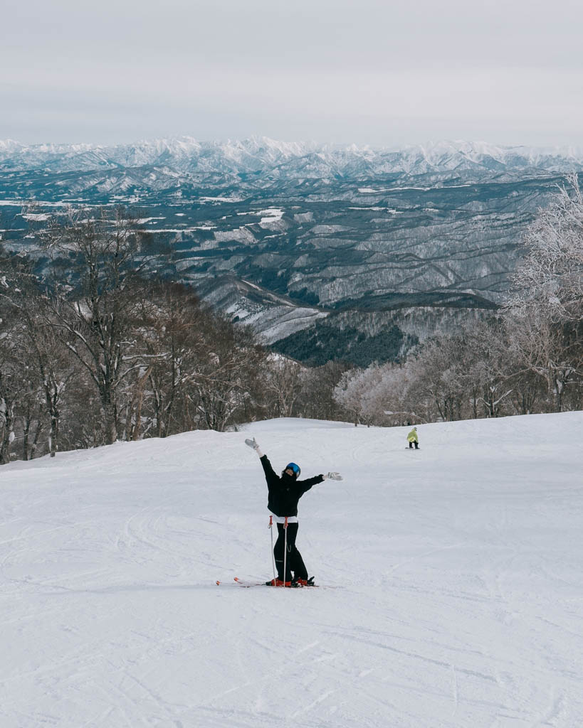 Skier taking in the mountain views from the top of Nozawa Onsen ski resort