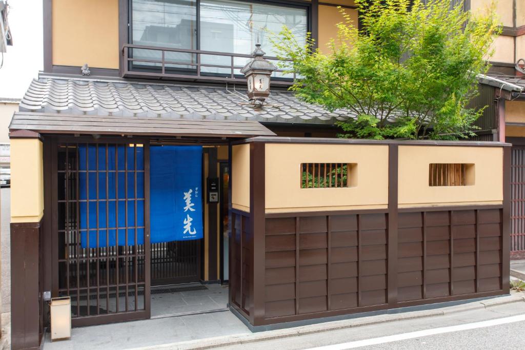 Traditional Japanese building entrance with tiled roof, wooden slat walls, and a blue noren curtain